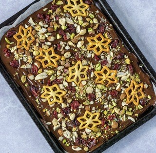<p>Mix the cranberries and nuts together and sprinkle over the entire layer of chocolate.<br />Add the festive pretzels</p>