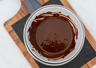 <p>Place the almond butter and coconut oil into a small saucepan and heat on low for a minute or so.</p><p>Next add in the chocolate and stir constantly until the chocolate has melted completely</p>